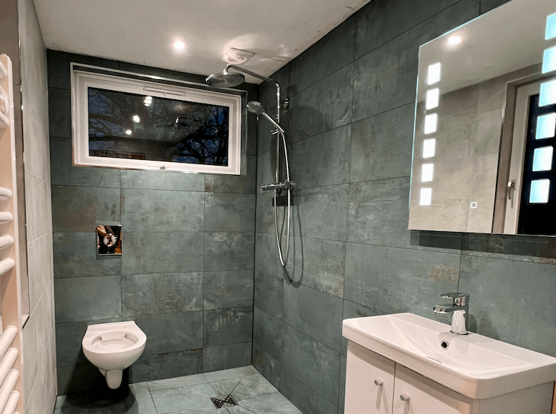 We love a beautifully tiled wet room, this green tiled open bathroom is fitted with care.